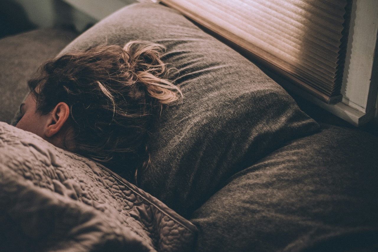 Mujer durmiendo en su habitación, descansando.